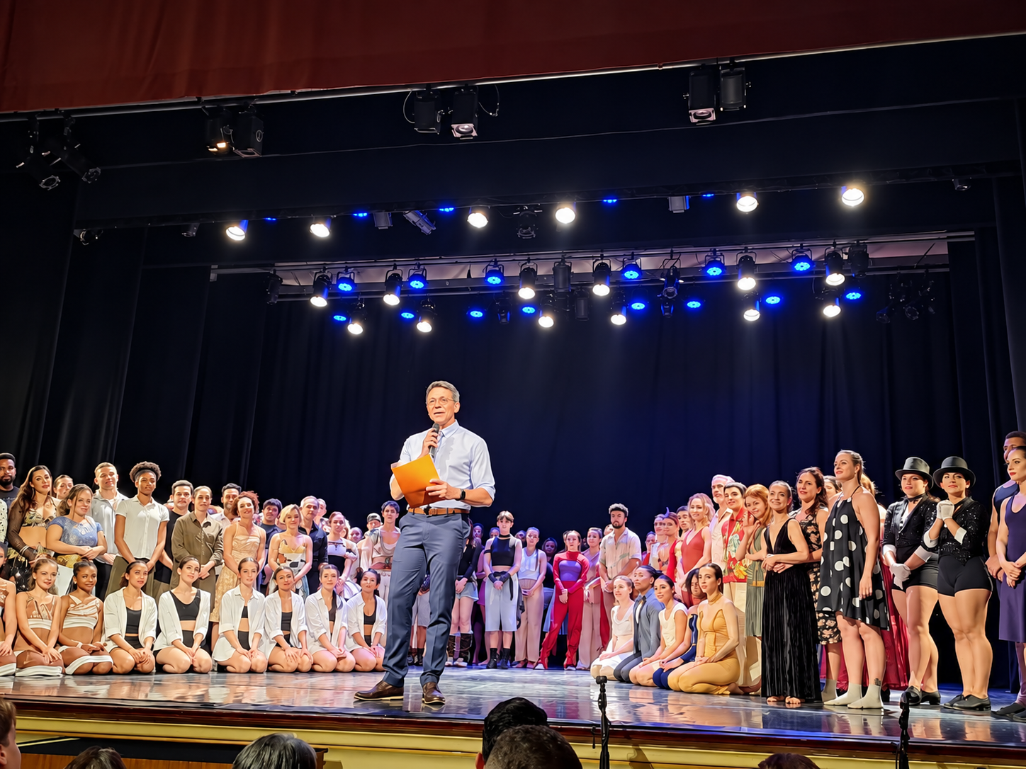 Elenco reunido no palco durante uma apresentação